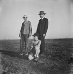 Doctor Zack Bobo (in suit) on a farm with a young man and a boy