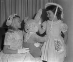 Two girls (not identified) dressed up for Easter, one holding a teddy bear, Arlington, Texas