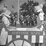 Two Six Flags employees beside cart selling souvenir maps to Six Flags Over Texas