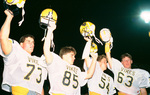 Three Lamar High School Vikings football players holding helmets