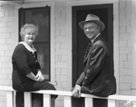 Portrait of a man and woman on porch by Basil Clemons 1887-1964