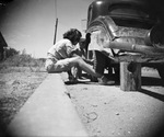 Woman is changing a car tire (Candid Groups), 1924-1946, undated by Basil Clemons 1887-1964