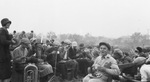 A group of young people having a meal outdoors by Basil Clemons 1887-1964