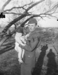 A man wearing a military outfit holding a baby by Basil Clemons 1887-1964