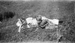 Woman and child reclining on grass. by Basil Clemons 1887-1964