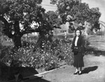 Portrait of a woman standing outside by Basil Clemons 1887-1964