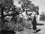 Portrait of a woman standing outside by Basil Clemons 1887-1964