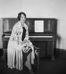 Portrait of a woman sitting at a piano by Basil Clemons 1887-1964