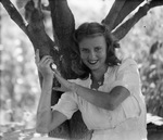 Portrait of a woman next to a tree by Basil Clemons 1887-1964