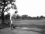 A man swinging a golf club by Basil Clemons 1887-1964