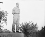 A man posing in a United States Army uniform and standing on a ledge by Basil Clemons 1887-1964