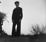 A man posing in a United States Navy uniform and standing on a ledge by Basil Clemons 1887-1964