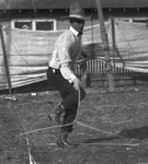 A cowboy performs with a lasso by Basil Clemons 1887-1964