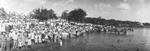 A very large group of people crowd the shoreline at Lake de La Fosse by Basil Clemons 1887-1964