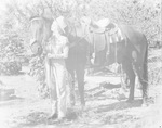 A cowgirl posing with her horse by Basil Clemons 1887-1964