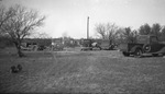 Several cars parked in a clearing in a wooded area by Basil Clemons 1887-1964