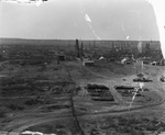 A small town with oil derricks scattered throughout by Basil Clemons 1887-1964