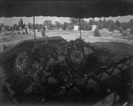 Flowers cover a casket sitting on top of an open grave at Breckenridge Cemetery, Texas by Basil Clemons 1887-1964