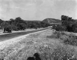 A countryside road with a parked car by Basil Clemons 1887-1964