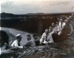 A group of men sitting on a hill overlooking a river by Basil Clemons 1887-1964