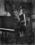 A woman standing next to a piano by Basil Clemons 1887-1964