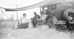 A family sitting next to a car by Basil Clemons 1887-1964