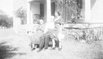 A family sitting outside a house by Basil Clemons 1887-1964