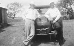 Two men leaning on a car by Basil Clemons 1887-1964