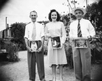 A family holding photos by Basil Clemons 1887-1964