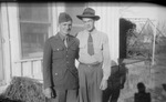 Two men standing outside by Basil Clemons 1887-1964