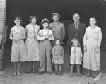 A family standing in a garage by Basil Clemons 1887-1964