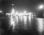 A wet street at night by Basil Clemons 1887-1964