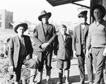 Four young men and a boy stand on a wooden sidewalk by Basil Clemons 1887-1964