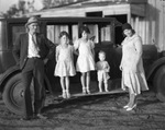 A young family pose in front of an automobile by Basil Clemons 1887-1964