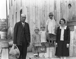 A family with three young girls pose for an outdoor photograph by Basil Clemons 1887-1964