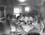 A group of people at the dinning table by Basil Clemons 1887-1964