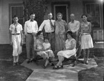 A family poses in front of a house by Basil Clemons 1887-1964