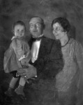 A couple wearing evening dress attire with a young girl by Basil Clemons 1887-1964