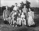 A family, including six children, pose for an outdoor photograph by Basil Clemons 1887-1964