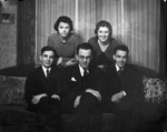 A couple with three teen-aged children pose around a sofa by Basil Clemons 1887-1964