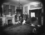 A couple with three young daughters pose in a very large room, possibly a living room by Basil Clemons 1887-1964