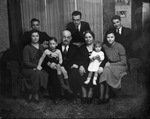 An extended family posing around a sofa by Basil Clemons 1887-1964