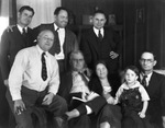 A family poses informally around a sofa by Basil Clemons 1887-1964