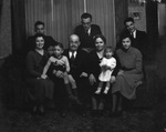 A family posing around a sofa by Basil Clemons 1887-1964