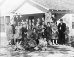 A very large family posing in front of a house by Basil Clemons 1887-1964