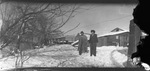 A couple on a snow-covered path by Basil Clemons 1887-1964