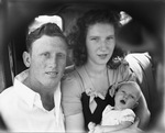 A young couple sitting in an automobile with a baby by Basil Clemons 1887-1964