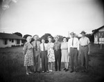 A family standing in a field by Basil Clemons 1887-1964