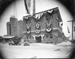 A three story brick building draped with bunting, Breckenridge, Texas by Basil Clemons 1887-1964