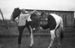 A man mounting a horse by Basil Clemons 1887-1964